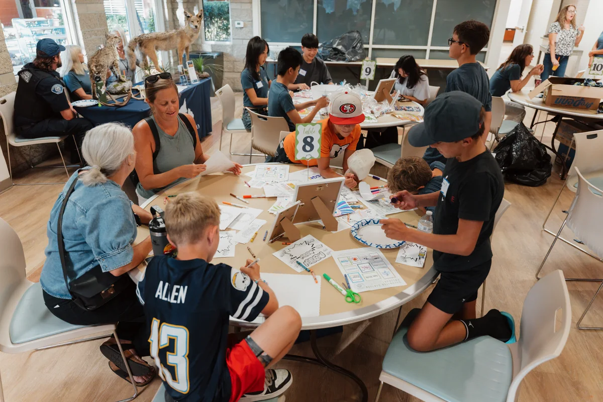 Lion’s Heart teen volunteers collaborating outdoors on a community outreach project. Photo by Nathan Palmer / OC Marketing Media